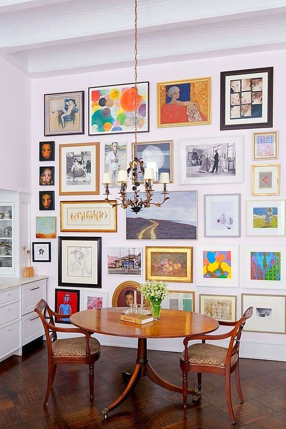 a colorful gallery wall with mismatching vintage frames, with and without mats, with art in various bright colors