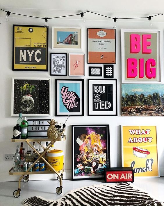 A colorful pop art gallery wall in various colors   posters for fun and with black and white frames is a bold idea