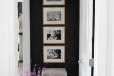 a cool one row grid gallery wall with stained wooden frames and black and white family pics – the shape gives the gallery wlal a modern look