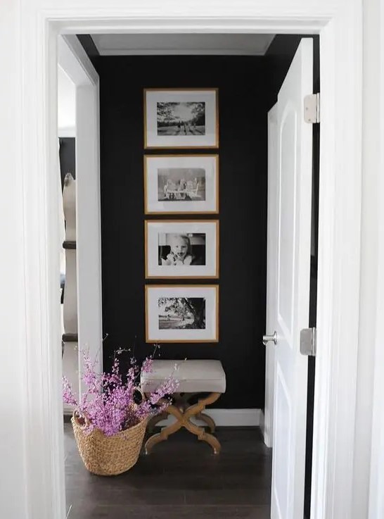 A cool one row grid gallery wall with stained wooden frames and black and white family pics   the shape gives the gallery wlal a modern look
