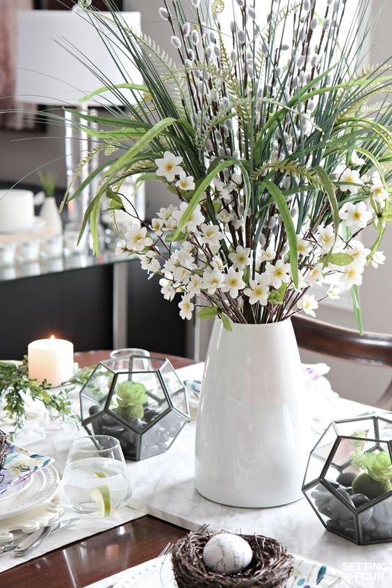 a creative spring centerpiece of a modern vase, willow, white blooms, greenery and grasses is a simple and cool idea