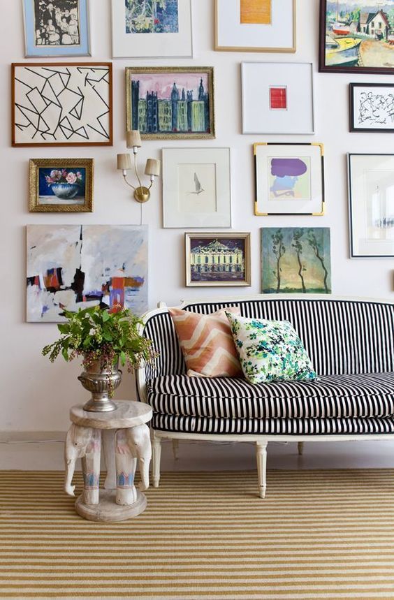 a fun and bold free form gallery wall with mismatching frames and without frames and various mismatching art
