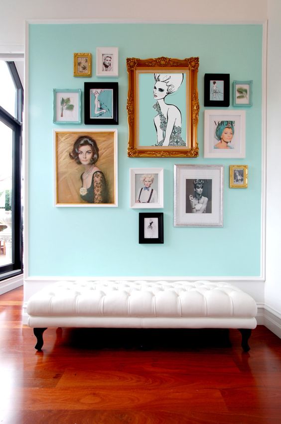 a glam free form gallery wall built around the central piece of art, with turquoise matting and mostly black and white or muted color art