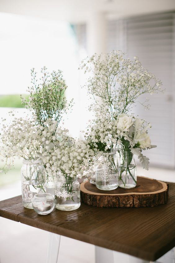 a gorgeous lovely white centerpiece of bottles and jars is a timeless idea for any spring tablescape