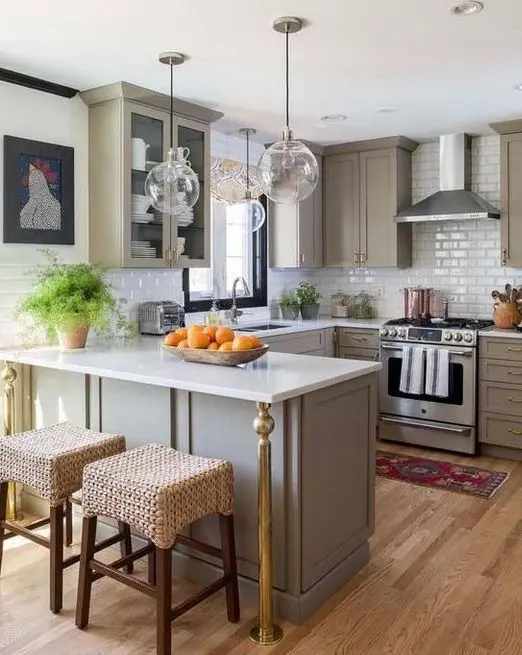 a grey farmhouse kitchen with a white countertop and a tile backsplash, glass bubble lamps and some art