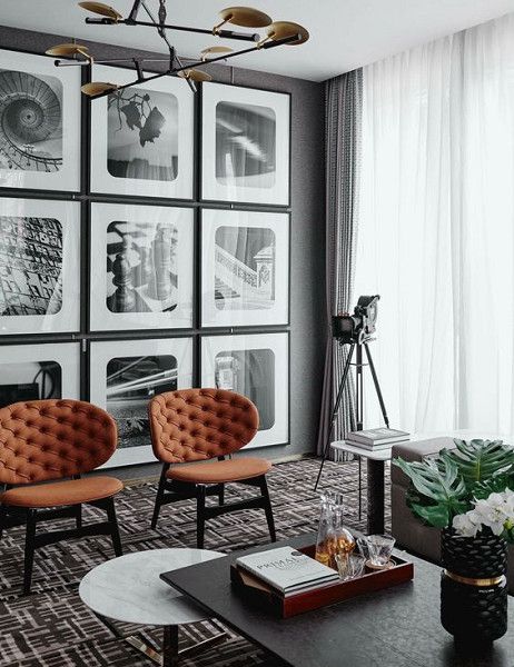 a grid gallery wall with thin black frames, white matting and black and white photos with curved angles feels retro chic