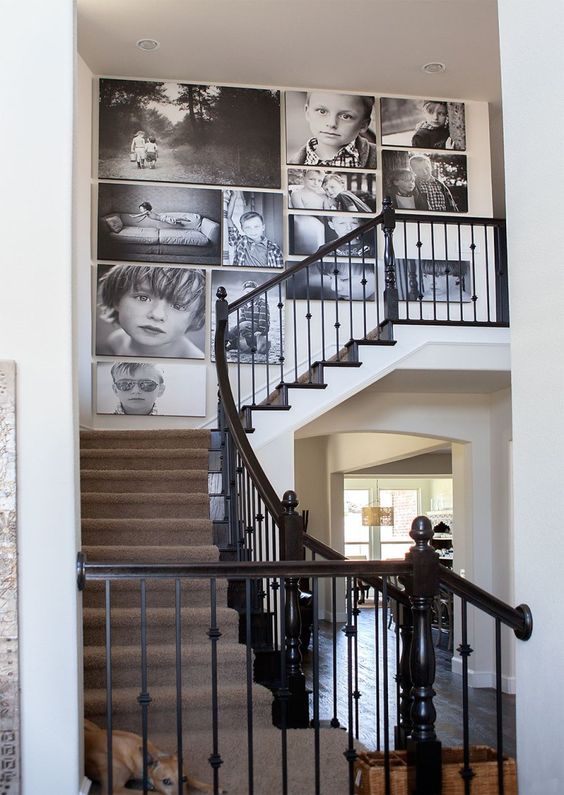a large black and white gallery wall with oversized photos and no frames, with a free form is a cool and bold idea