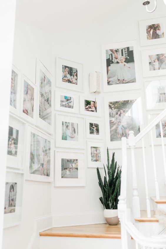a large gallery wall done with IKEA Ribba ledges and colorful family photos with matting is amazing and very fresh
