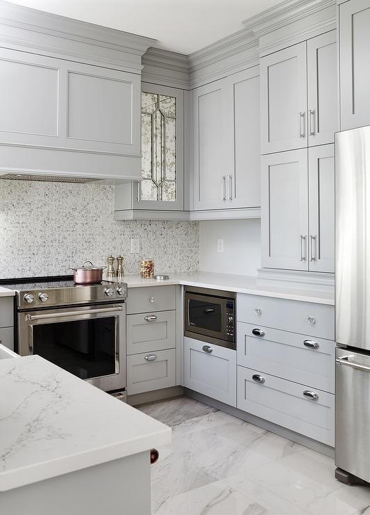 a light grey farmhouse kitchen with a mosaic tile backsplash and white stone countertops is elegant and cool