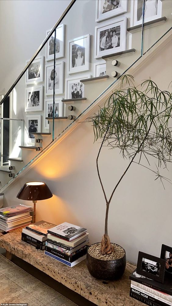 a lovely black and white free form gallery wall with matching white frames brings style and chic to this stairway space