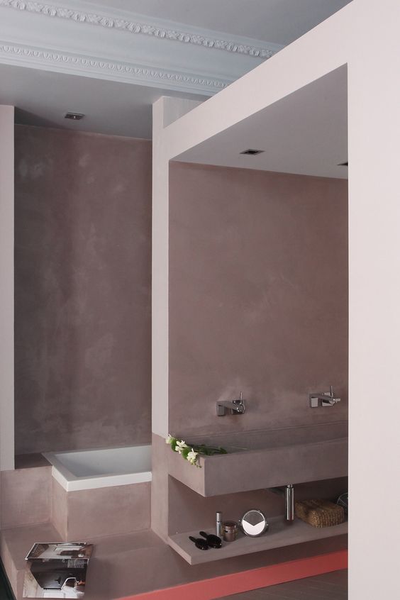 a mauve bathroom with a separated sink and bathtub space and refined decor in Parisian style