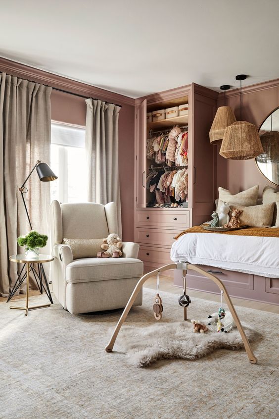 a mauve kid’s room with a raised bed, a mobile and a chair, some pendant lamps is a chic place