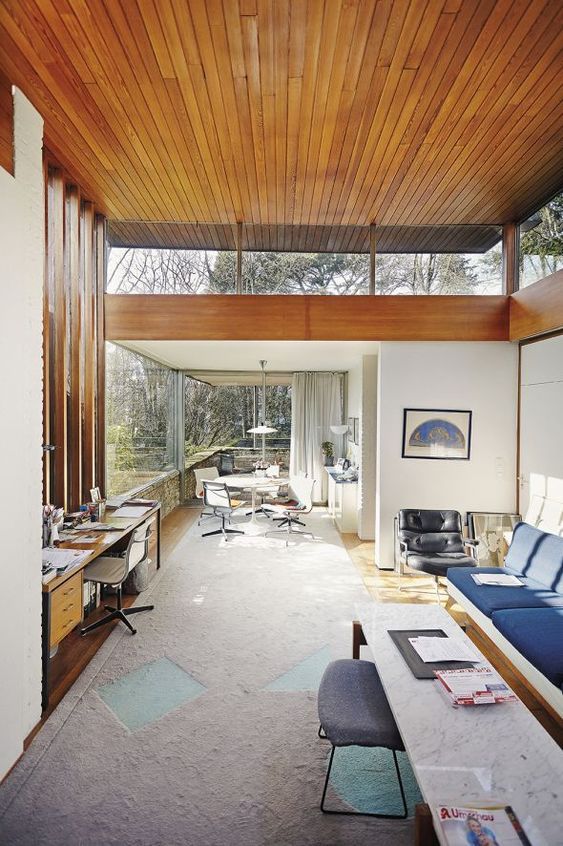 A mid century modern space with colroful furniture, glazed walls and clerestory windows plus a wood clad ceiling