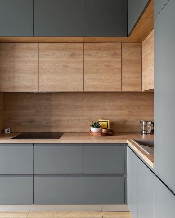 A minimalist grey and stained wood L shaped kitchen is a stylish and very refined space