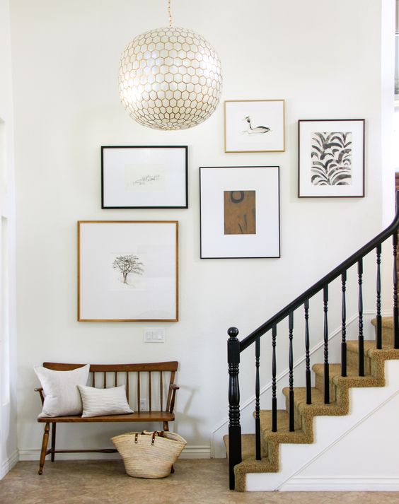a minimalist staircase gallery wall in black, white and neutrals with mismatching black and neutral frames