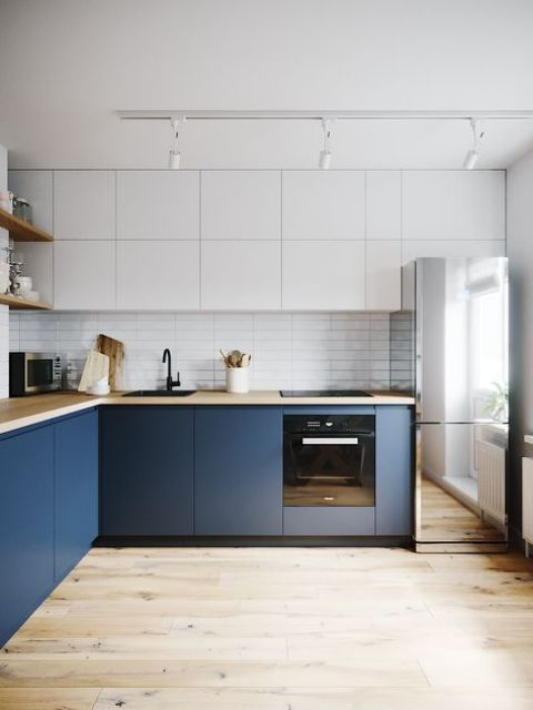 a minimalist two-tone kitchen with butcherblock countertops and a mirror fridge is a very edgy solution