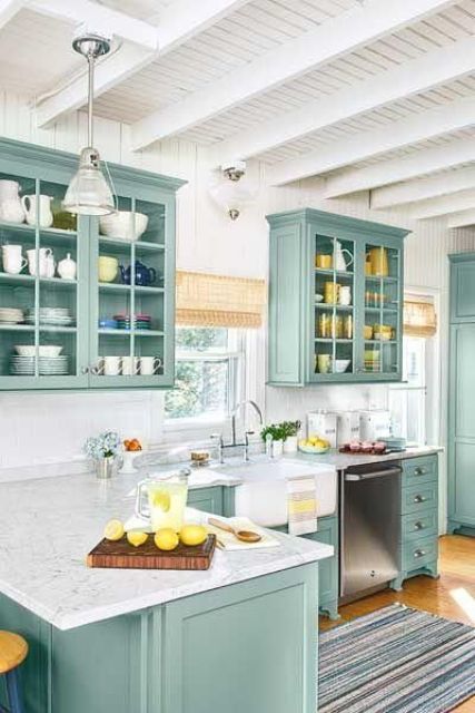 A mint L shaped kitchen with a white stone countertop, woven shades and touches of yellow is very chic