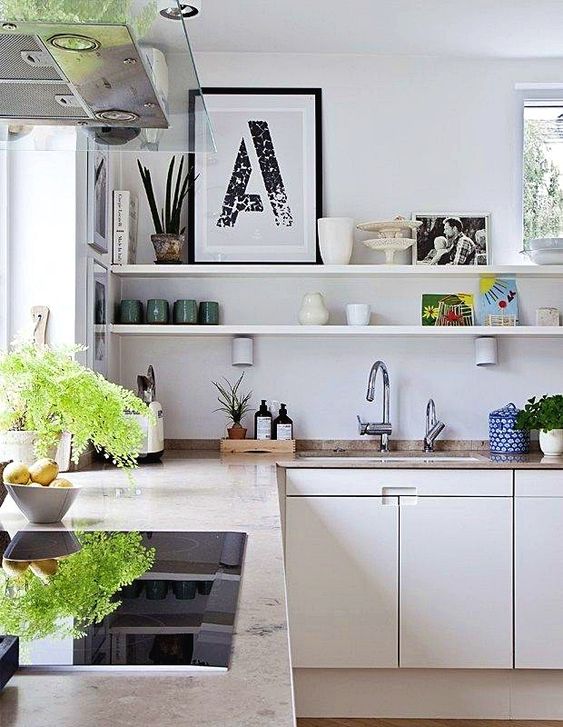 a neutral L-shaped kitchen, open shelves, greenery and stone countertops plus windows for natural light
