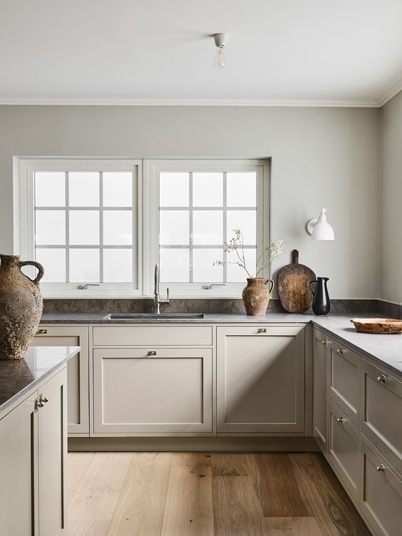 A refined Nordic L shaped kitchen with a grey stone backsplash and countertops is very calming and soothing