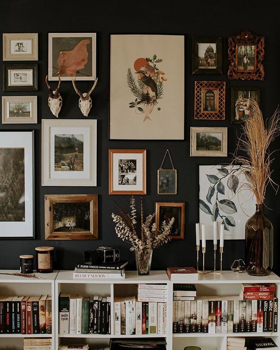 a refined and chic gallery wall with mismatching frames, artworks and antlers is a pretty idea with a vintage feel