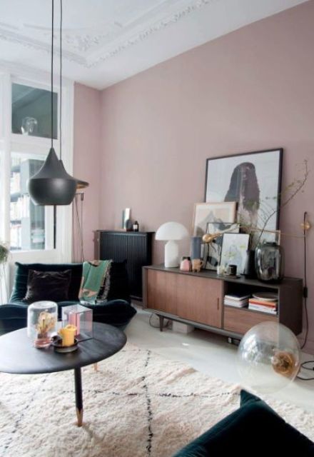 a refined mauve living room with dark furniture, some artworks, pretty dark and gold lamps is chic