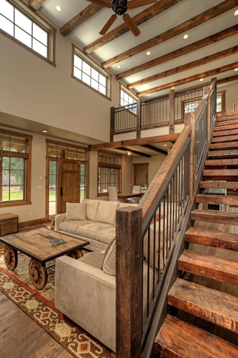 a rustic living room with wooden beams on the ceiling and built-in lights, clerestory windows, neutral furniture and a coffee table on casters