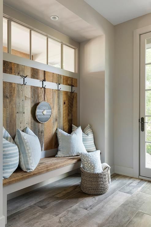 a rustic mudroom with a glass door and a clerestory window for additional light inside is a cozy space