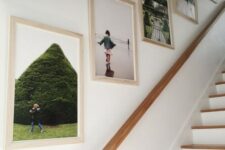 a simple and cool grid gallery wall with family photos in light-stained frames is a cool idea for a modern staircase