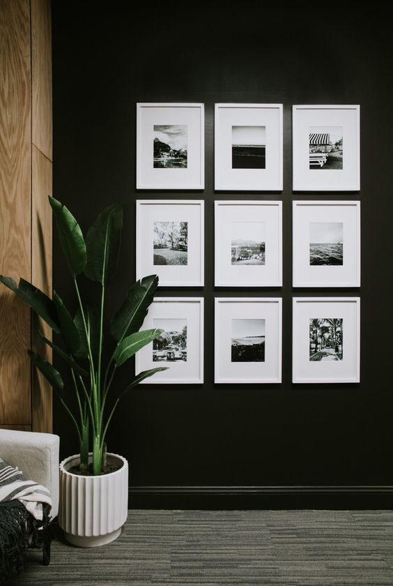 a simple symmetrical gallery wall with black and white prints in matching white frames is a cool and chic idea
