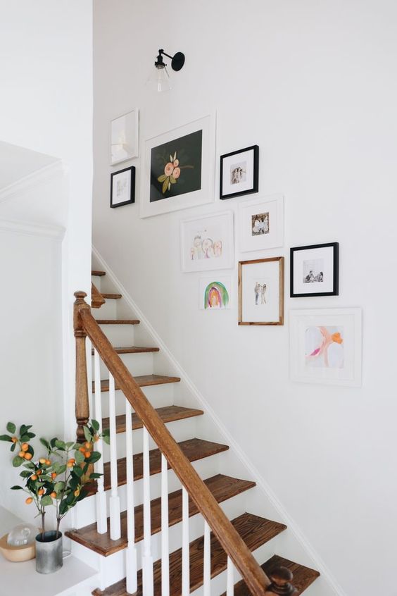 a small and cool free form gallery wall with mismatching frames and colorful artworks is a pretty idea to style the space
