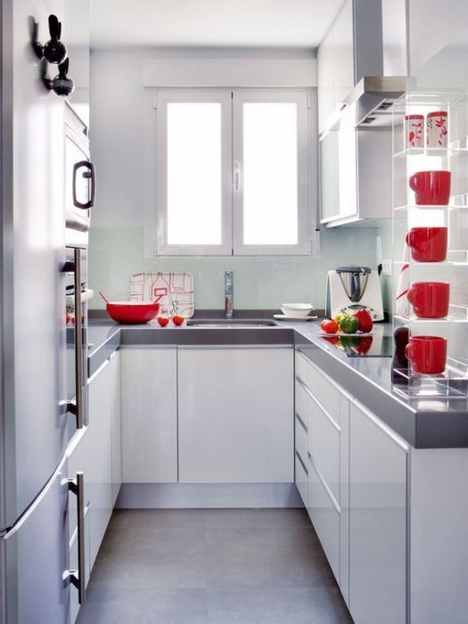 a small contemporary white kitchen with grey countertops and red tableware is a lovely space to be and is cozy
