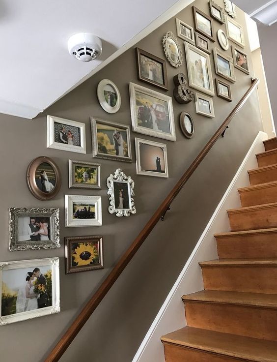 a stairway gallery wall with mismatching vintage frames and various family pics is a stylish way to style the space