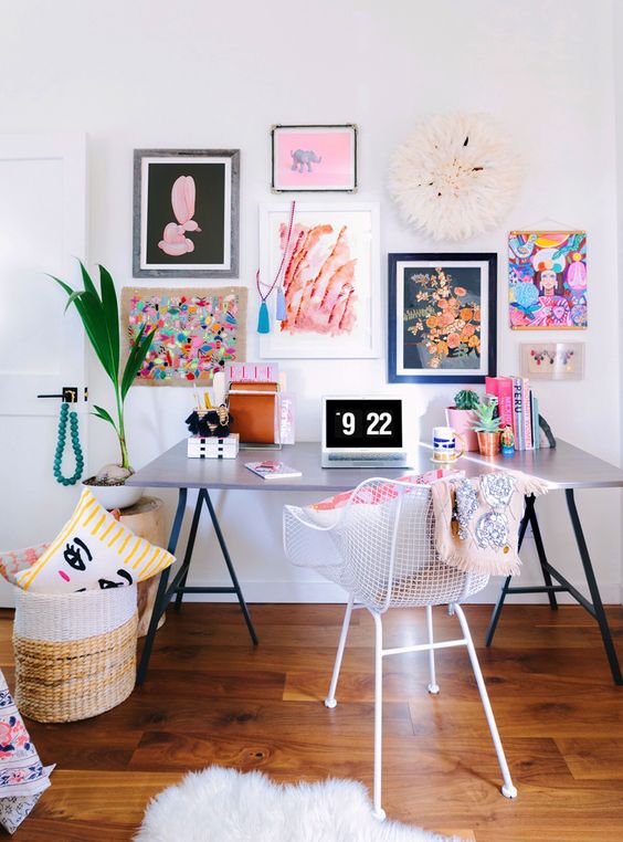 a super colorful gallery wall with mismatching frames and bold floral and abstract art will add a creative touch to the office