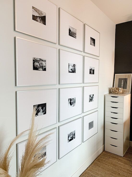 a super modern gallery wall with thin silver frames, mauch matting and small black and white photos