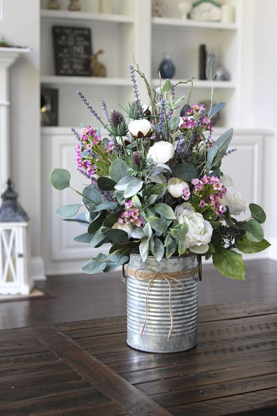 a tin can with white and pink blooms, lavender, thistles and foliage is a pretty rustic decoration for spring