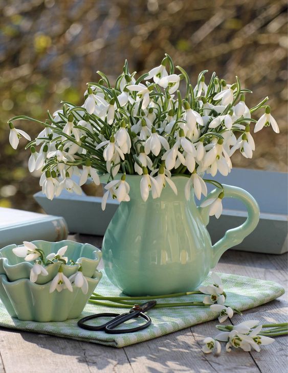 a vintage green milk jug with snowdrops is a simple and cute spring centerpiece to rock