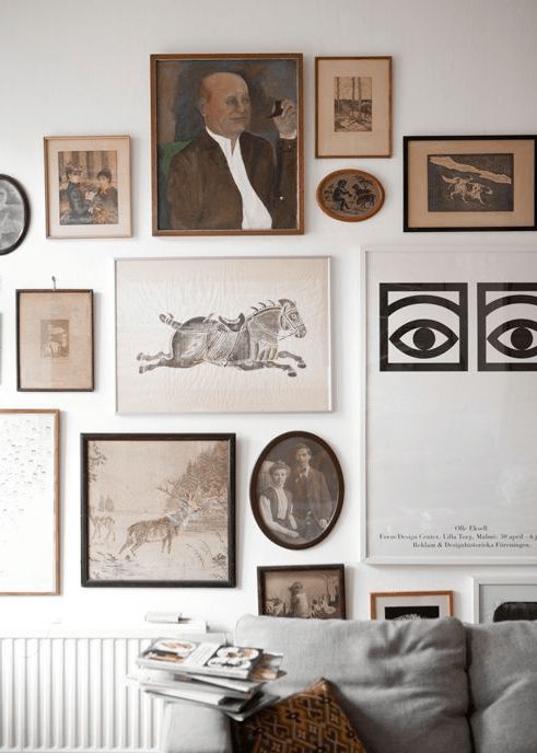 A vintage inspired free form gallery wall with black, white and gilded frames and various shapes is interesting
