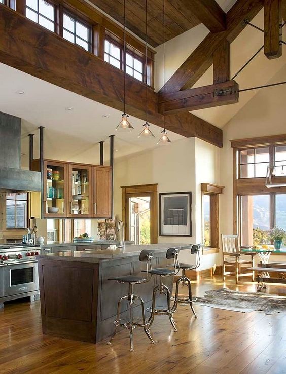 a welcoming rustic space with stained wooden beams, a wooden ceiling and pendant lamps, large usual windows and additional clerestory ones