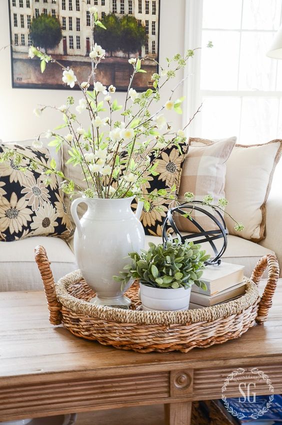 a white vase with greenery and blooming branches can be used as a simple spring centerpiece