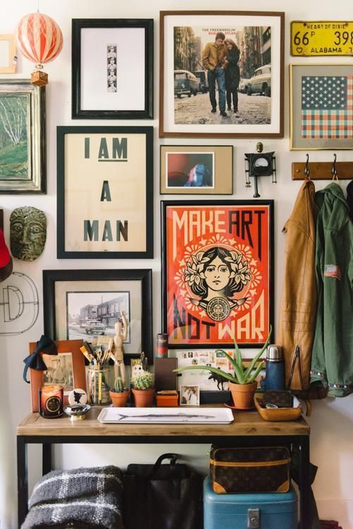 an eclectic gallery wall with various art and mismatching frames plus some pretty souvenirs is very cool