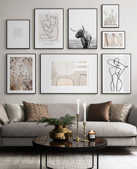 an elegant free form gallery wall with thin black frames and white mats plus muted color and black and white art