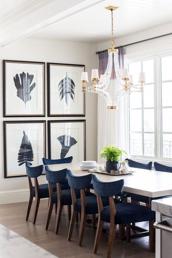 an elegant grid gallery wall with dark frames and silhouette prints is a great addition to this modern dining zone