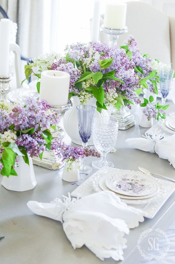 lush lilac arrangements in white vases amd white candles for a refined vintage-inspired spring tablescape