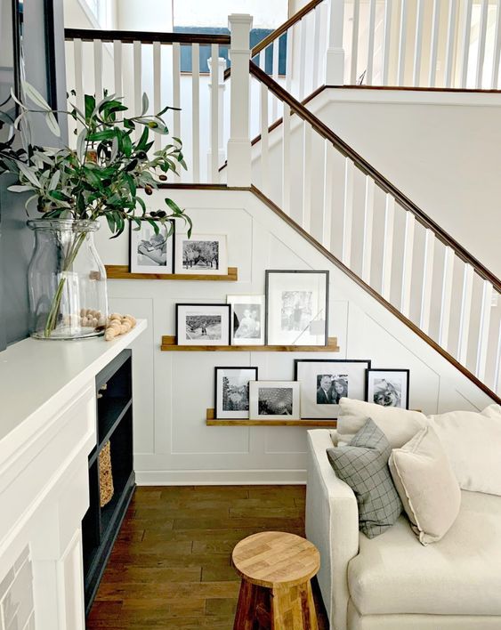 stained ledges with black and white artworks and black and white frames are amazing to style the staircase