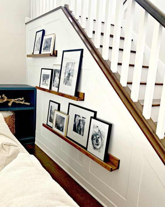 stained ledges with black and white family pics in mismatching frames to style the staircase a bit