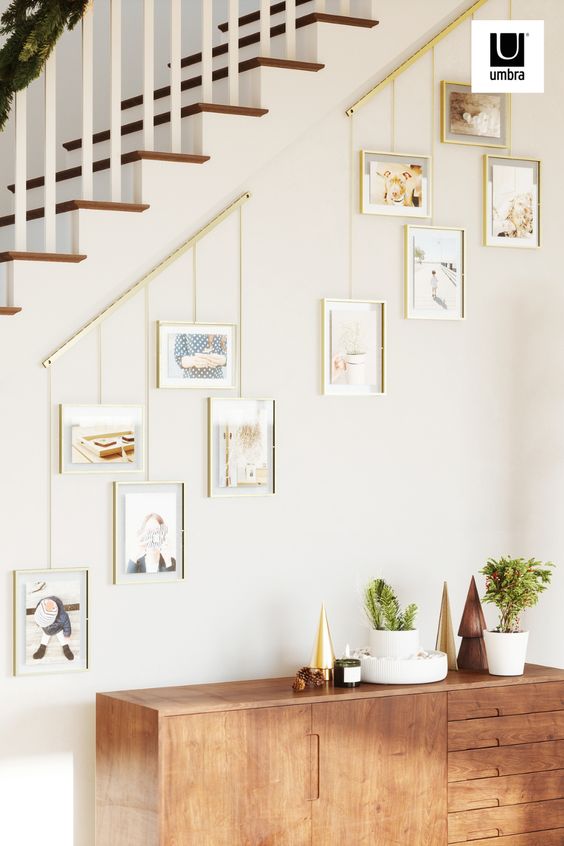 Wall mounted brushed metal ledge with clips and brackets to hold five gallery style picture frames of various size