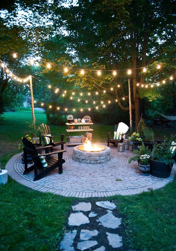 02 a backyard fire pit with string lights over the space is warm and welcoming and looks very cool