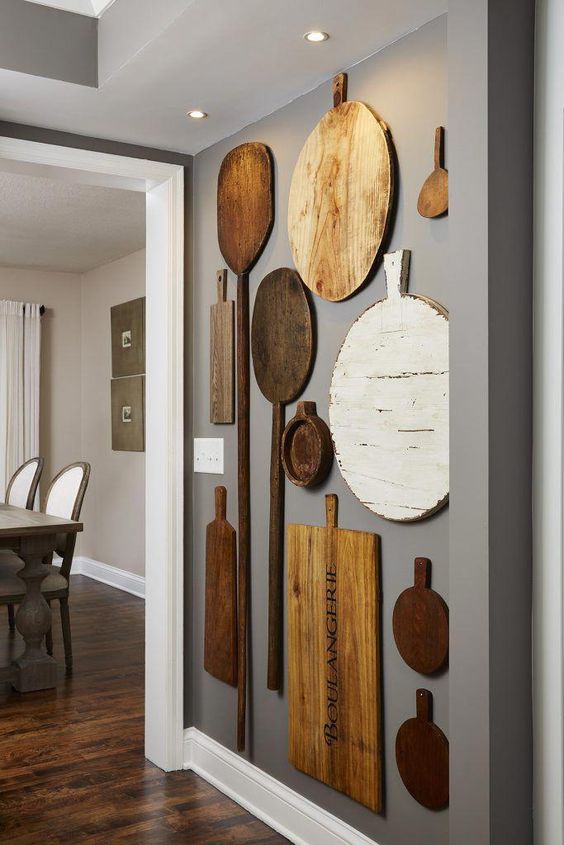 rustic kitchen wall decor with mismatching cutting boards and oars is a lovely idea for a farmhouse space