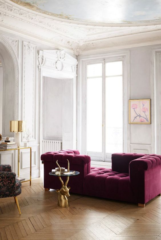 14 an exquisite neutral living room with a purple couch of velvet, a glass and gold console, a quirky chair and a cool antler table