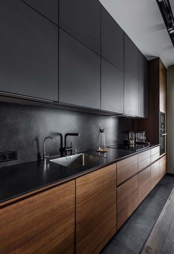 15 a moody minimalist kitchen with stained and black cabinets, a black countertop and a backsplash plus an integrated hood that isn’t seen